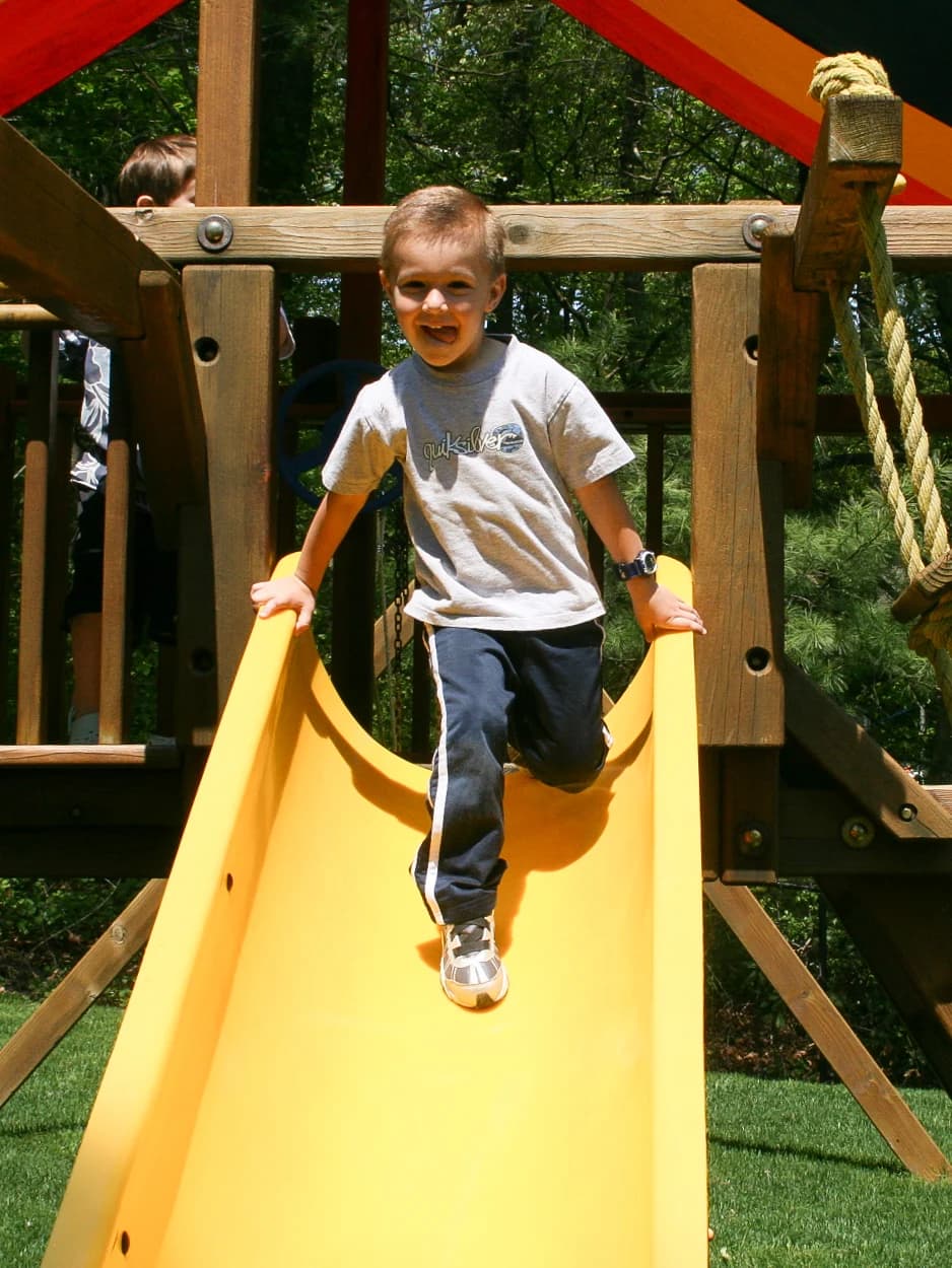 A childhood photograph on a yellow playground slide