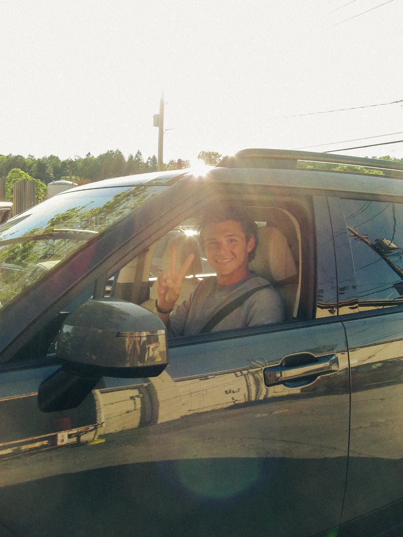 A smiling driver through an open vehicle window in the evening light